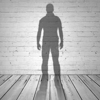 shadow-man-white-brick-wall-wooden-floor-44721986.jpeg